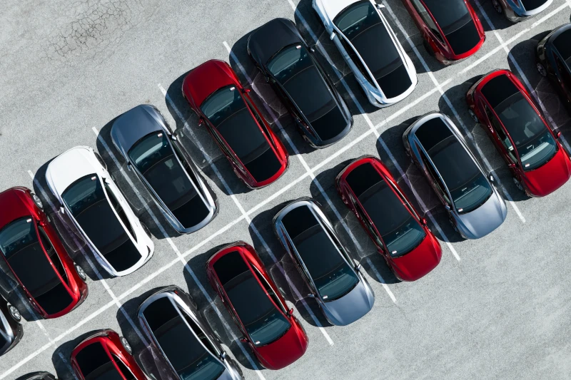 Luftaufnahme von geparkten Autos auf einem Parkplatz mit klar markierten Parklinien.
